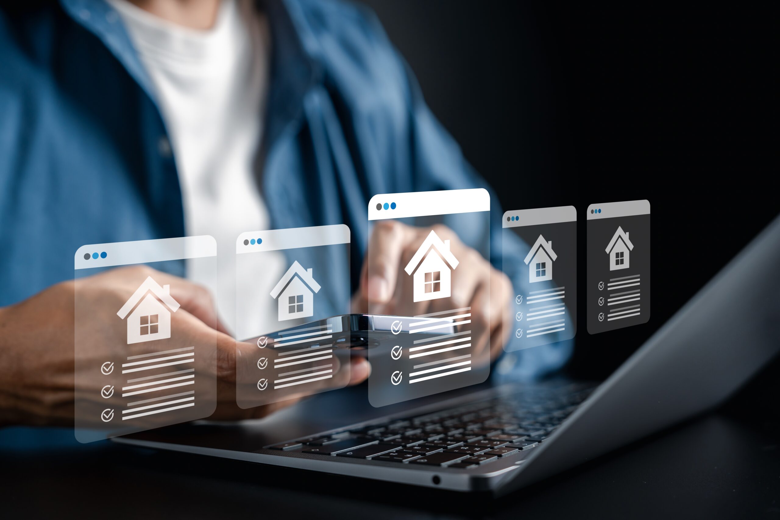 Woman looking at real estate online with housing icons hovering as a touch screen off the computer