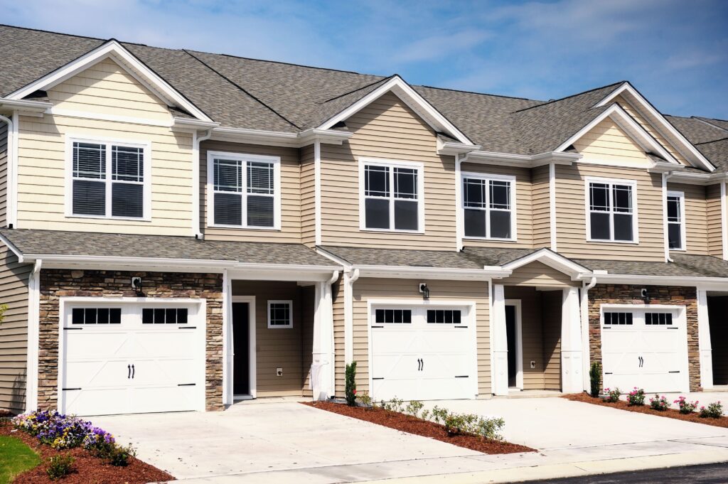 A Row Of Modern Townhomes With Beige Siding White Trim